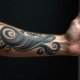 Gros plan sur un bras tatoué en noir et gris